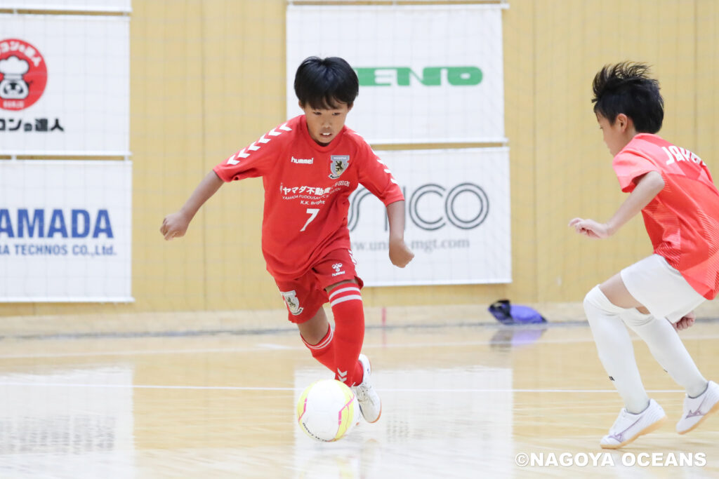 自身を持ってフットサルをプレーする男の子