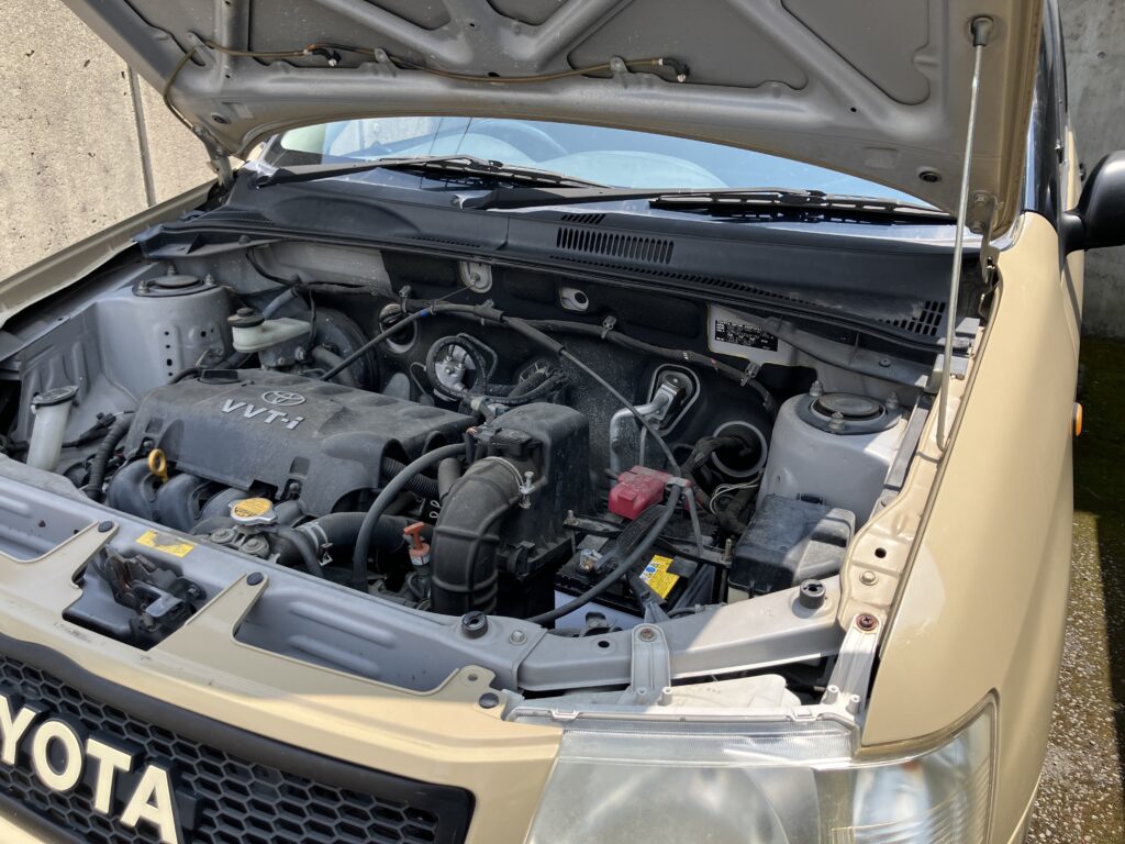 車のボンネットを開けてエアフィルター交換作業をしている様子