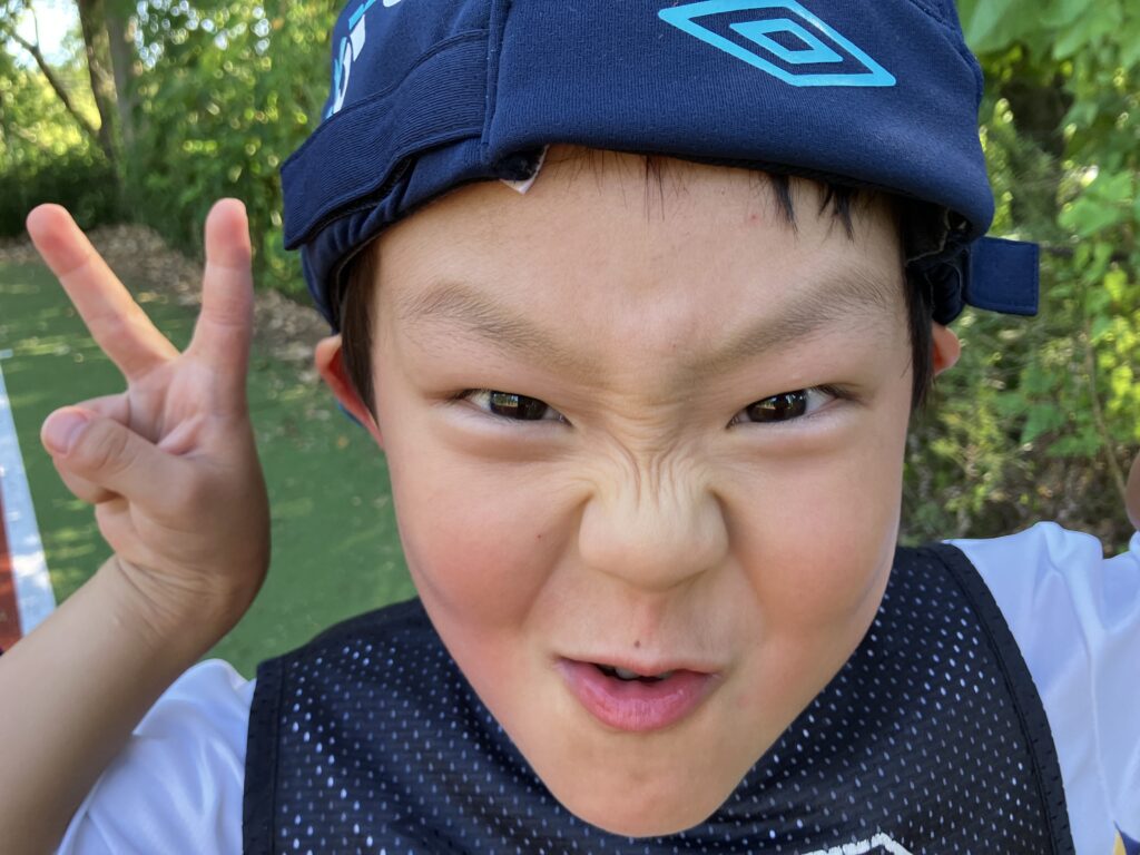 真剣な表情でポーズを決めるフットサルスクールの男の子。考える力やチャレンジ精神をテーマにしたブログ記事。
