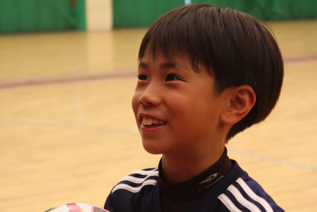 名古屋オーシャンズフットサルスクール夏合宿で笑顔を見せる小学生の参加選手